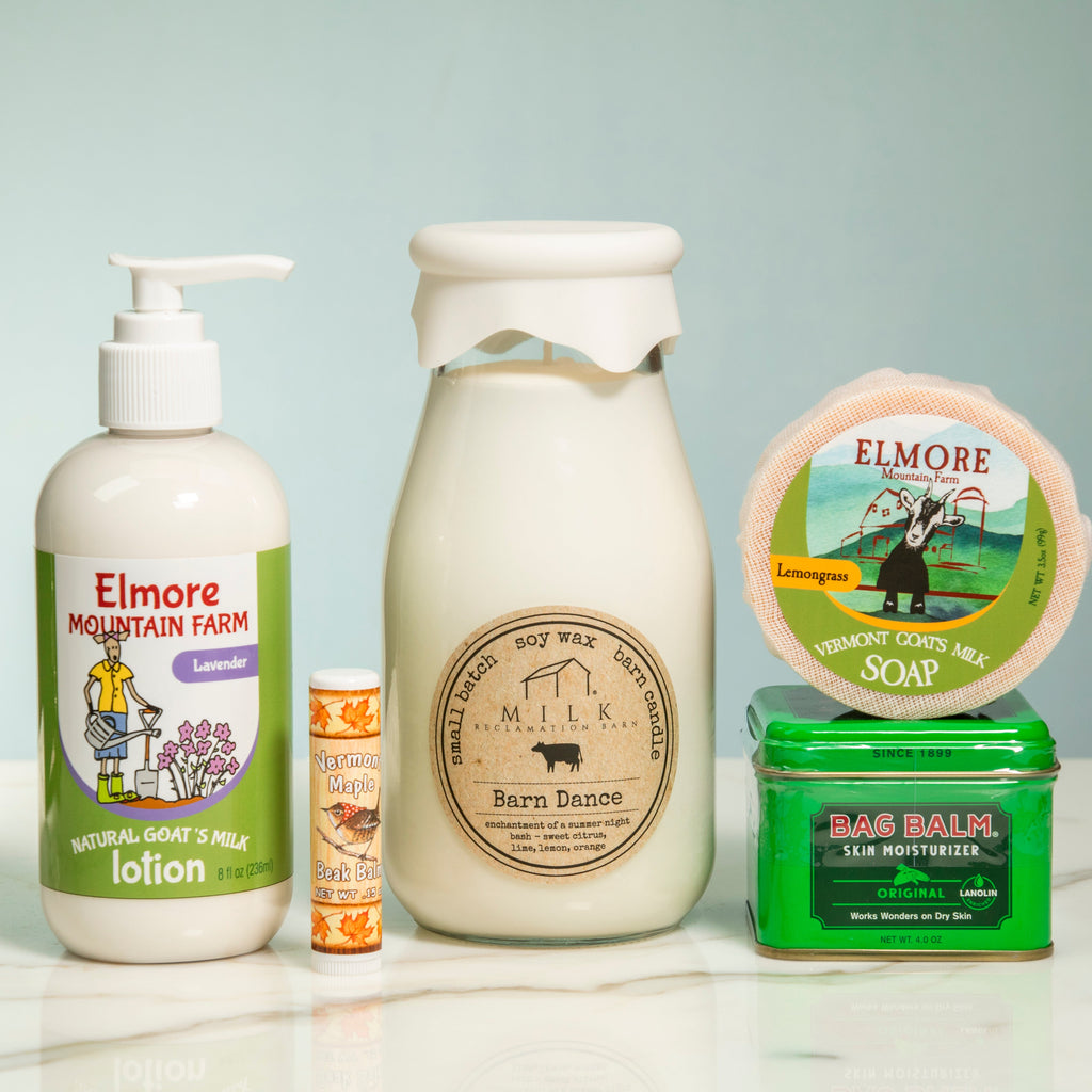 Collection of skincare products and a candle on a light surface with a neutral background