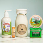 Collection of skincare products and a candle on a light surface with a neutral background