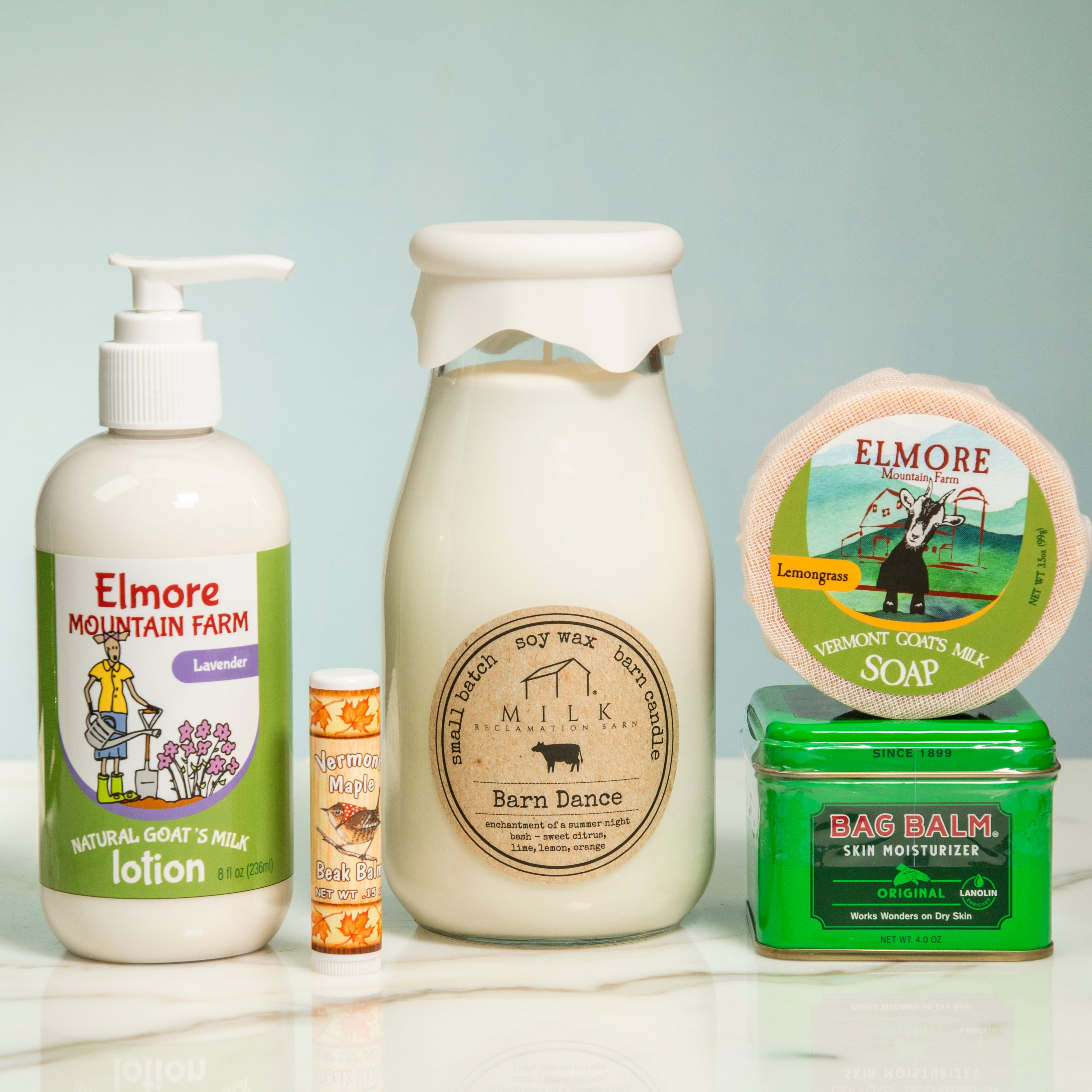 Collection of skincare products and a candle on a light surface with a neutral background